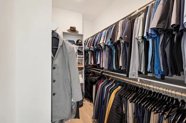 a view of walk in closet with clothes and shoes