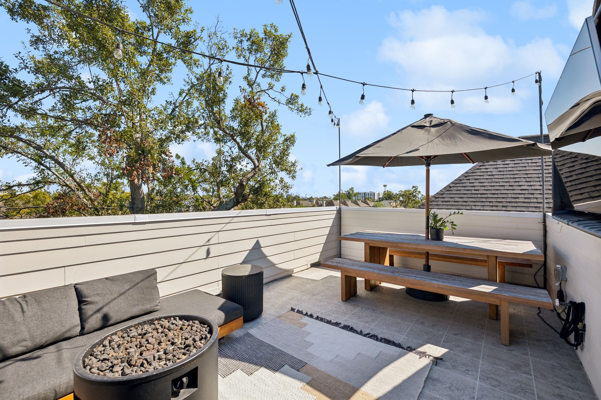 1413 West 23rd Street Houston, TX 77008 - Photo 35 of 39 a roof deck with table and chairs under an umbrella