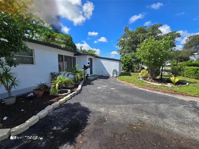 a view of a house with a yard and tree