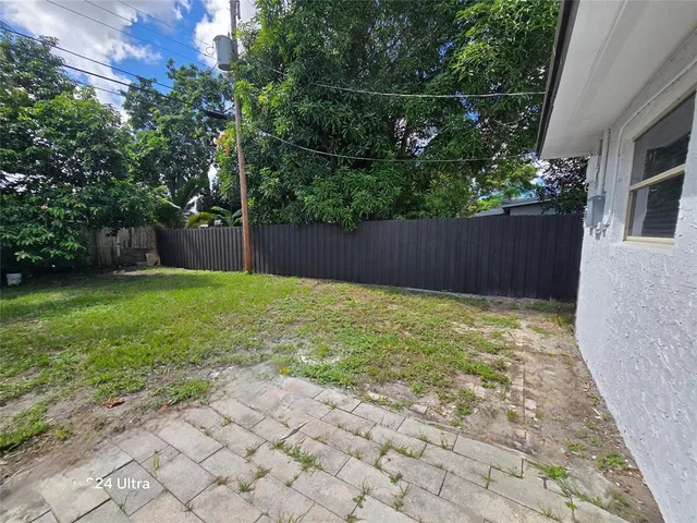 a view of backyard with potted plants and a wooden fence