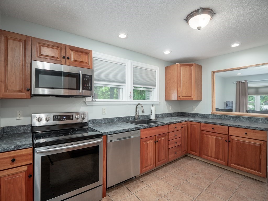 82 Rangeway Road Billerica, MA 01862 - Photo 25 of 40 a kitchen with sink a microwave a stove and cabinets