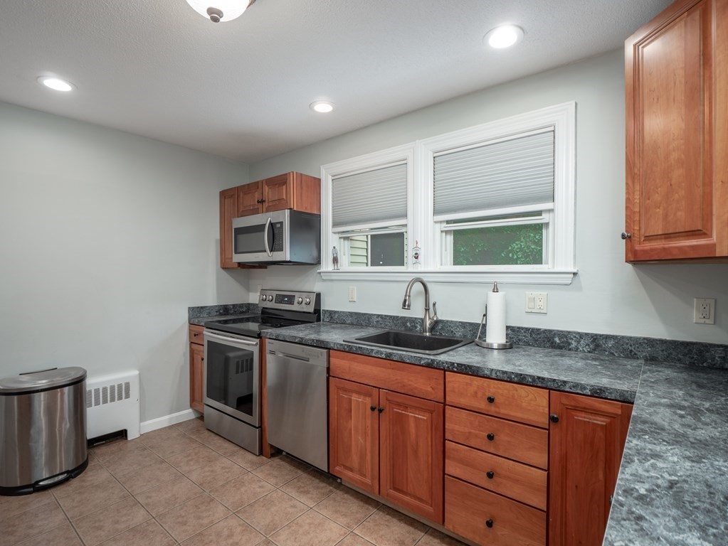 82 Rangeway Road Billerica, MA 01862 - Photo 27 of 40 a kitchen with granite countertop stainless steel appliances a stove sink and microwave