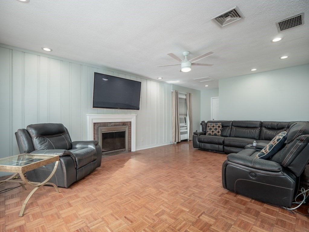 82 Rangeway Road Billerica, MA 01862 - Photo 34 of 40 a living room with furniture a fireplace and a flat screen tv