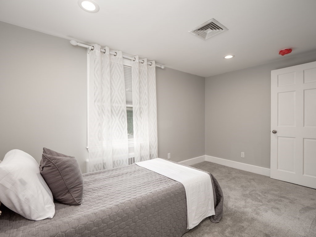 82 Rangeway Road Billerica, MA 01862 - Photo 8 of 40 a bedroom with a large bed and a chandelier