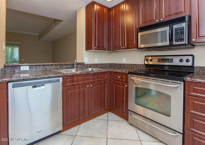 9745 Touchton Road, Unit 2028 Jacksonville, FL 32246 - Photo 2 of 20 a kitchen with granite countertop wooden cabinets and stainless steel appliances