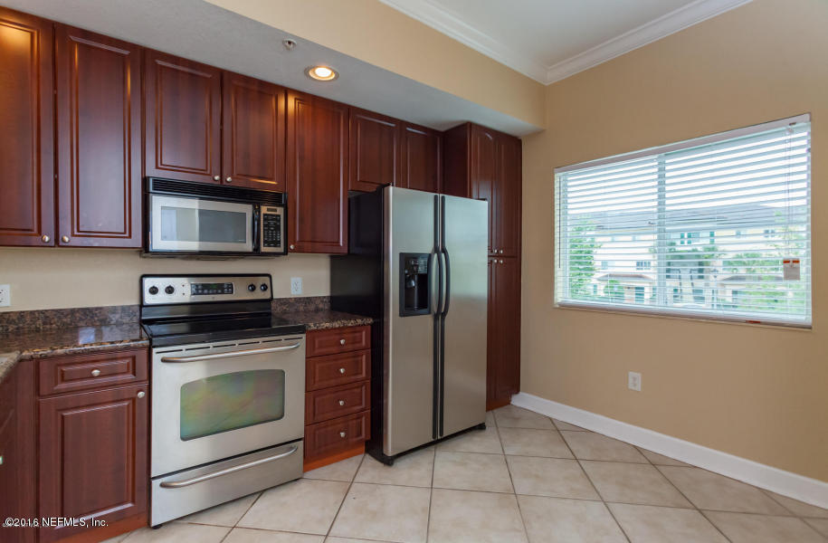9745 Touchton Road, Unit 2028 Jacksonville, FL 32246 - Photo 3 of 20 a kitchen with granite countertop wooden cabinets stainless steel appliances and a window