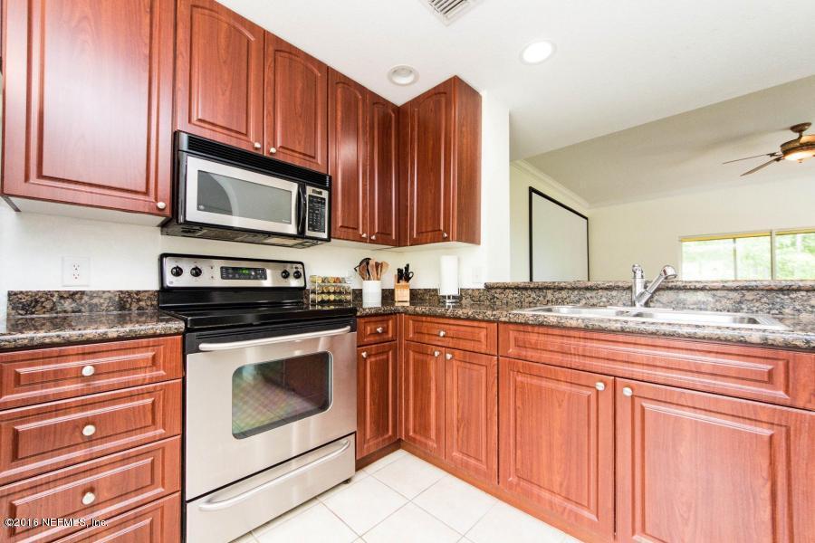 9745 Touchton Road, Unit 2028 Jacksonville, FL 32246 - Photo 4 of 20 a kitchen with granite countertop wooden cabinets stainless steel appliances and a counter space