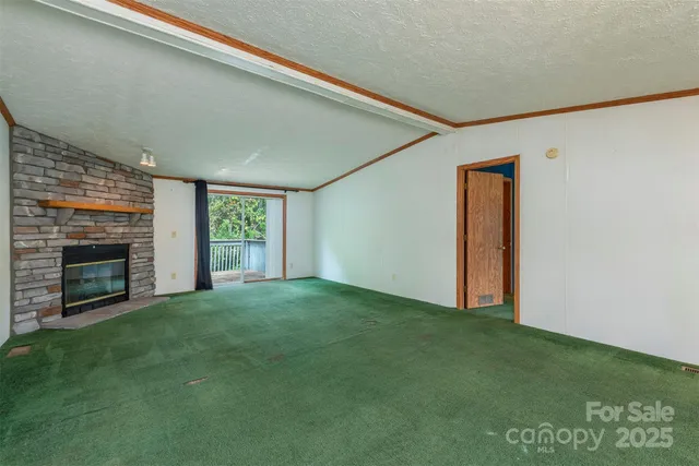 a view of an empty room with a fireplace and a window