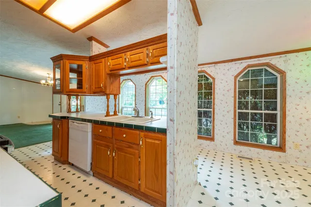 a hallway with granite countertop a refrigerator and a sink