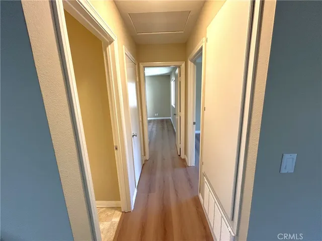 a view of a hallway with wooden floor and closet