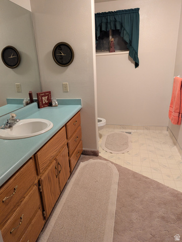 1040 West Mill Road Ferron, UT 84523 - Photo 57 of 117 Vanity with integrated sink, wood-finish cabinetry, and a light-colored countertop