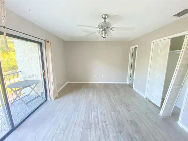 a view of a big room with wooden floor and a chandelier fan
