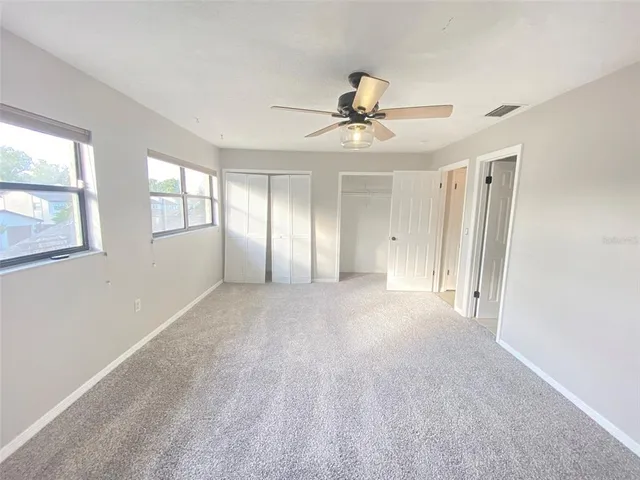 a view of an empty room and a ceiling fan
