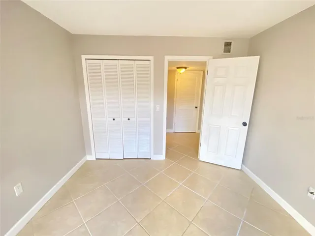 a view of a hallway with wooden floor and a bathroom