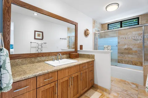 a bathroom with a granite countertop sink and a mirror