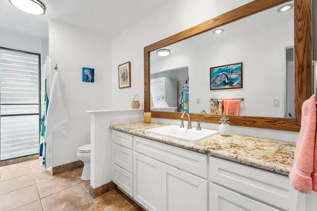 a bathroom with a granite countertop sink and a mirror