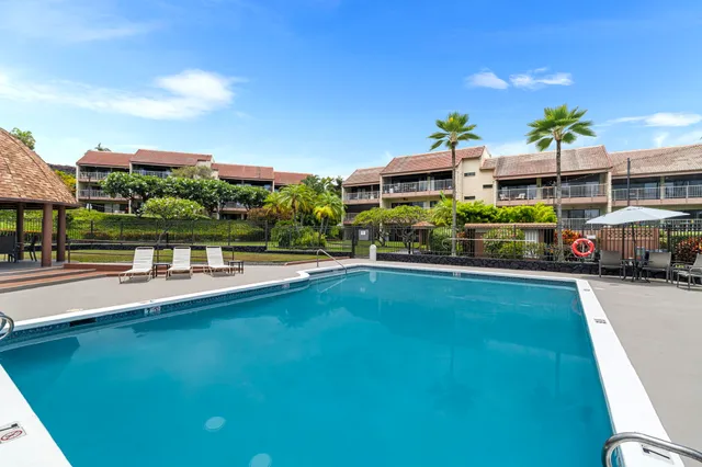 a swimming pool view with a seating space and garden view