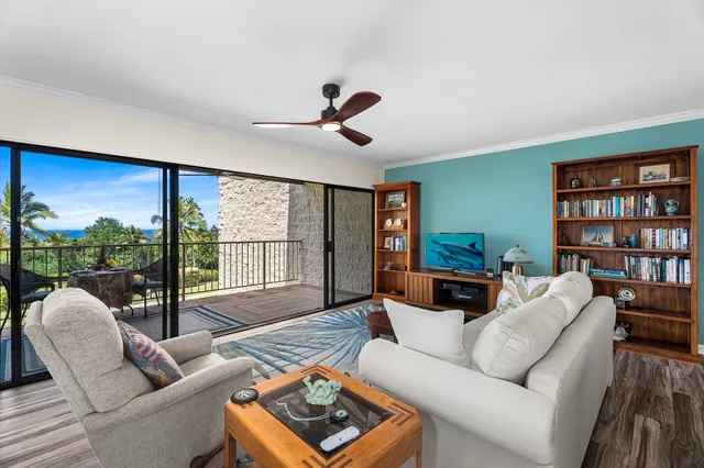 a living room with furniture ceiling fan and a floor to ceiling window