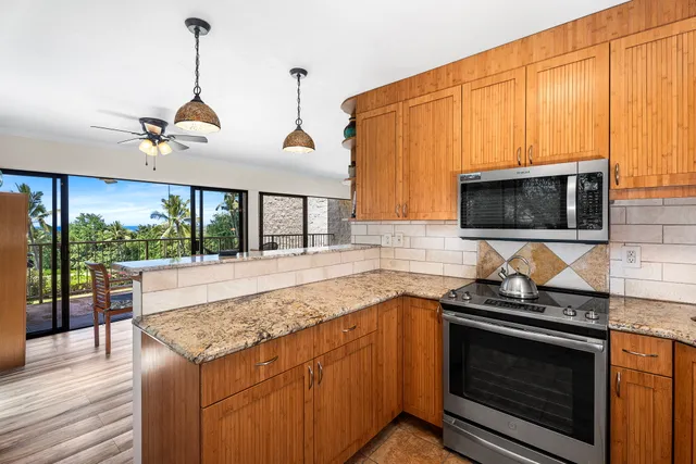 a kitchen with stainless steel appliances granite countertop a stove a sink and a microwave