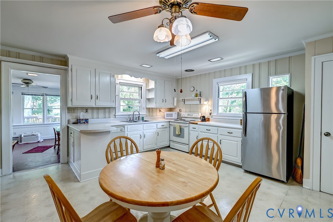 1817 Pocoshock Boulevard North Chesterfield, VA 23235 - Photo 19 of 41 a kitchen with stainless steel appliances granite countertop a refrigerator a stove a sink a dining table and chairs with wooden floor