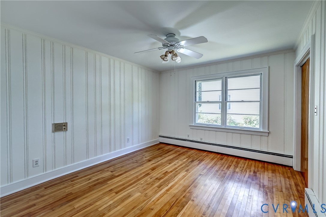 1817 Pocoshock Boulevard North Chesterfield, VA 23235 - Photo 25 of 41 an empty room with wooden floor chandelier fan and windows