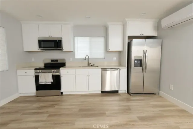 a kitchen with stainless steel appliances a refrigerator stove and microwave