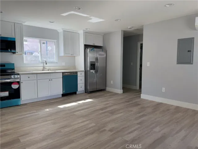a view of a kitchen with a sink and a refrigerator