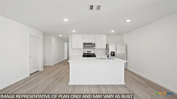 a view of a kitchen island a sink wooden floor and living room