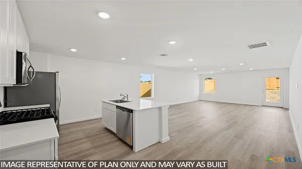 a view of a kitchen with a sink cabinets and wooden floor