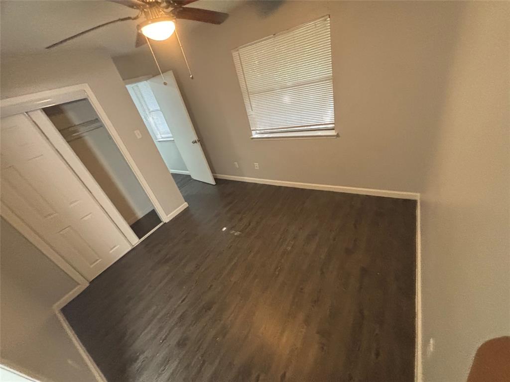 301 Rolston Road, Unit 317103 Irving, TX 75060 - Photo 6 of 9 Spacious room featuring dark wood-finish flooring, a ceiling fan with integrated lighting, and neutral wall tones