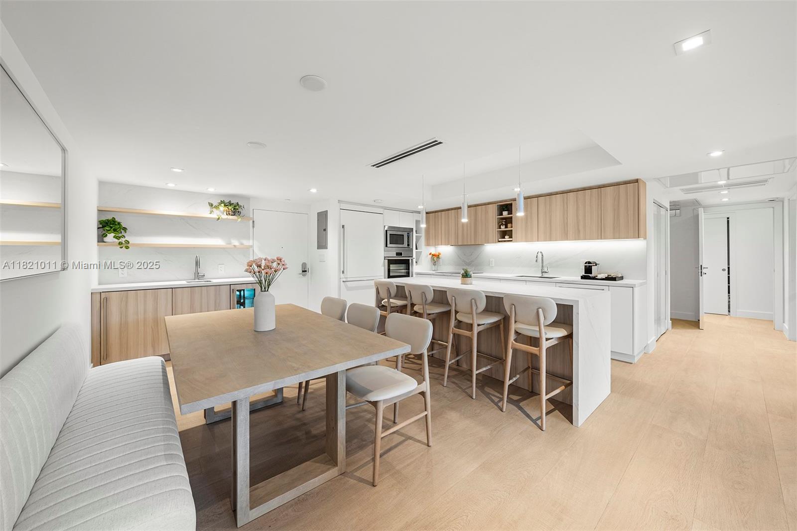 2301 Collins Avenue, Unit 630 Miami Beach, FL 33139 - Photo 36 of 48 a kitchen with stainless steel appliances kitchen island granite countertop a table chairs sink and cabinets