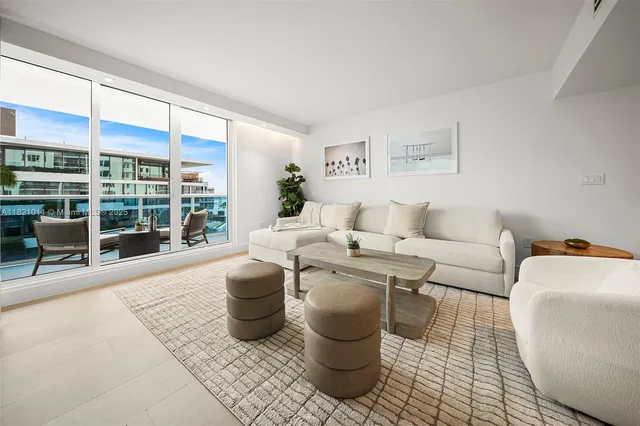 a living room with furniture and a floor to ceiling window