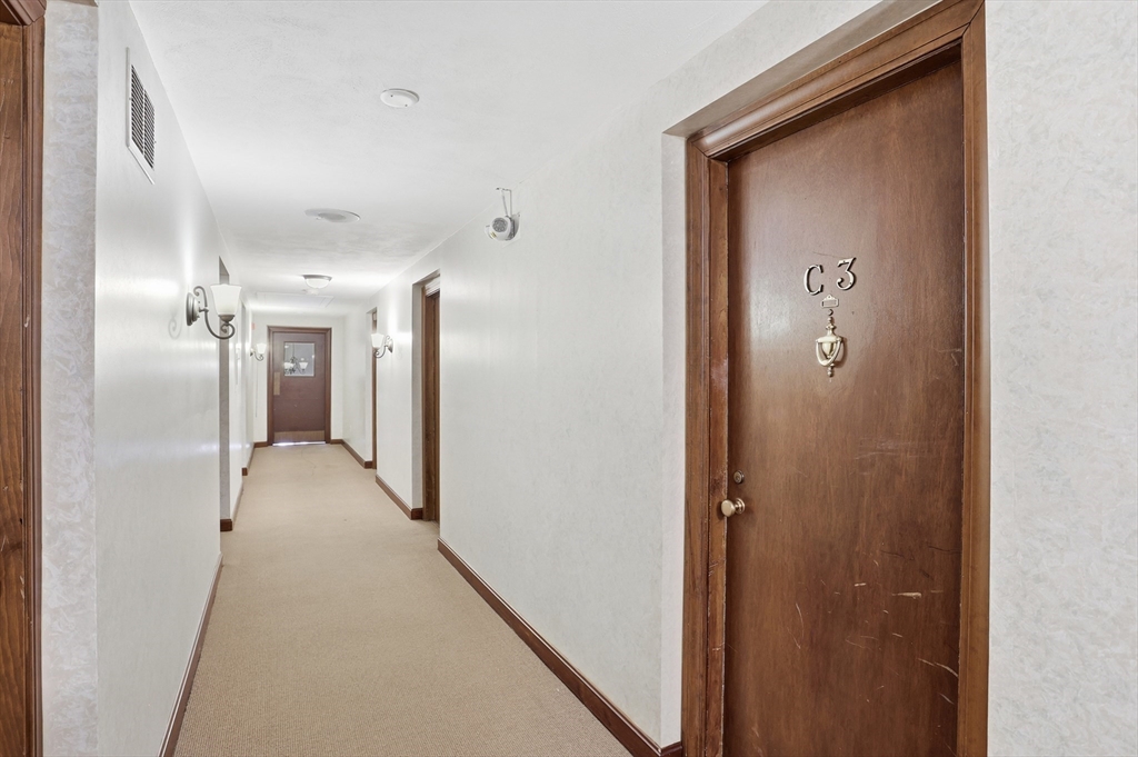 209 Great Road, Unit C3 Acton, MA 01720 - Photo 16 of 24 a view of a hallway with wooden cabinets