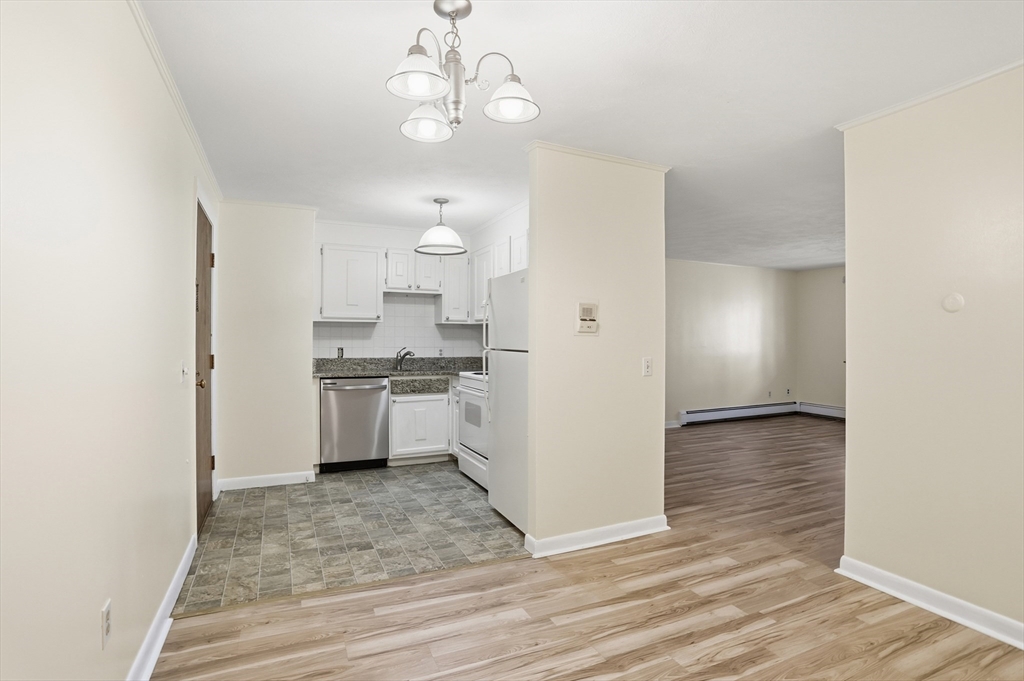 209 Great Road, Unit C3 Acton, MA 01720 - Photo 3 of 24 a kitchen with kitchen island white cabinets and stainless steel appliances