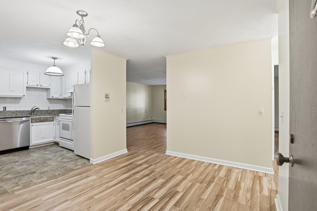 209 Great Road, Unit C3 Acton, MA 01720 - Photo 8 of 24 a view of empty room with wooden floor and kitchen