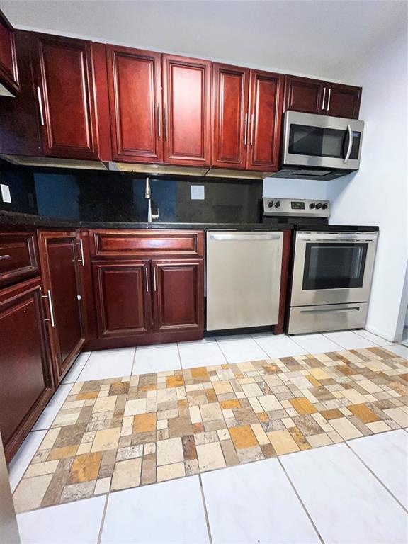 7925 Fairview Drive, Unit 101 Tamarac, FL 33321 - Photo 3 of 48 a kitchen with granite countertop a stove top oven microwave and cabinets