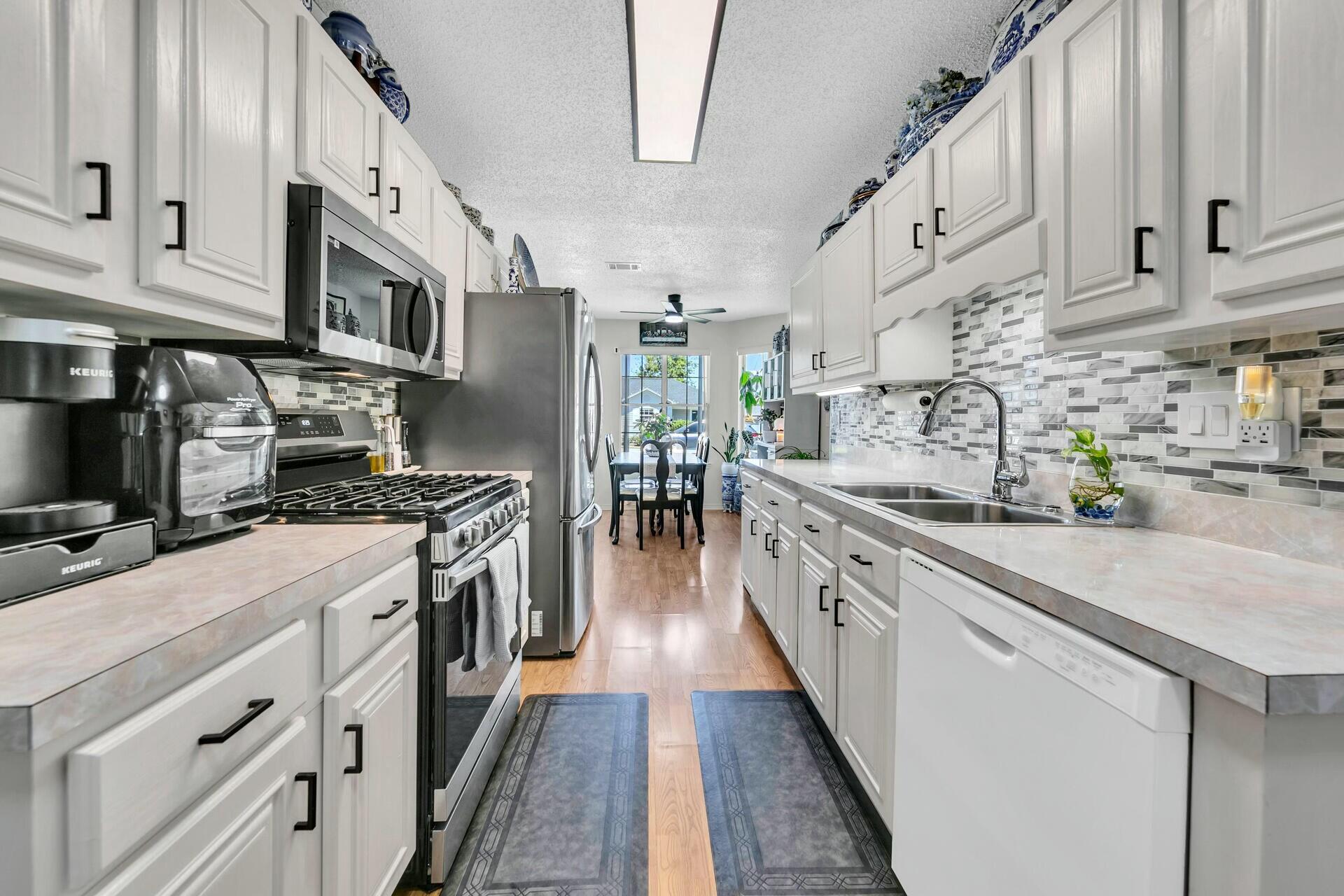 420 Apple Drive Crestview, FL 32536 - Photo 10 of 32 a large kitchen with stainless steel appliances granite countertop a lot of counter space and wooden floors