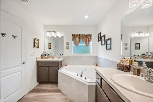 a bathroom with a double vanity sink toilet mirror and shower