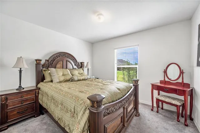 a bedroom with bed and paintings on the wall