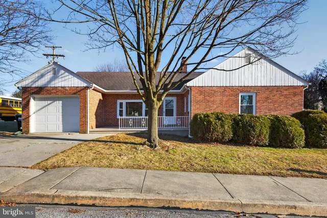 a view of a white house with a large tree
