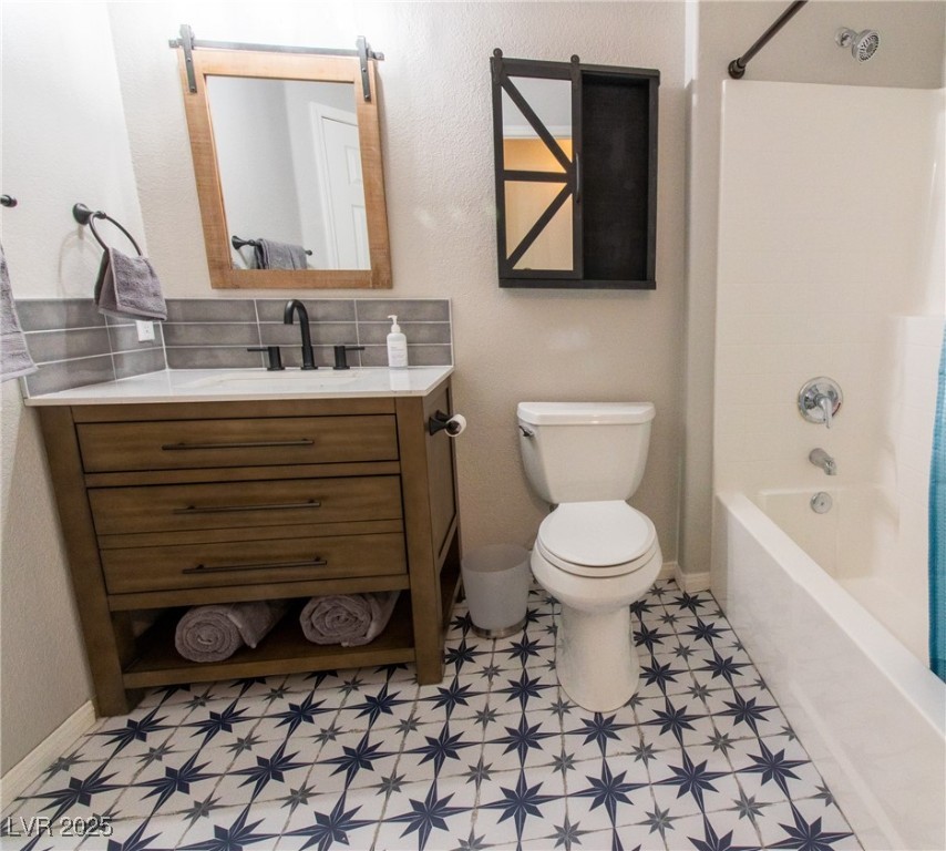10550 West Alexander Road, Unit 2068 Las Vegas, NV 89129 - Photo 13 of 47 Bathroom featuring a textured wall, shower / bath combination, vanity, and decorative backsplash