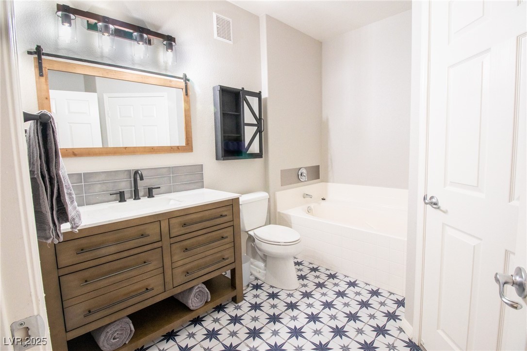 10550 West Alexander Road, Unit 2068 Las Vegas, NV 89129 - Photo 18 of 47 Full bath featuring vanity, a bath, and decorative backsplash