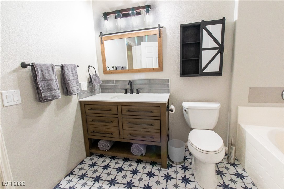 10550 West Alexander Road, Unit 2068 Las Vegas, NV 89129 - Photo 19 of 47 Bathroom featuring vanity, a bathtub, and a textured wall