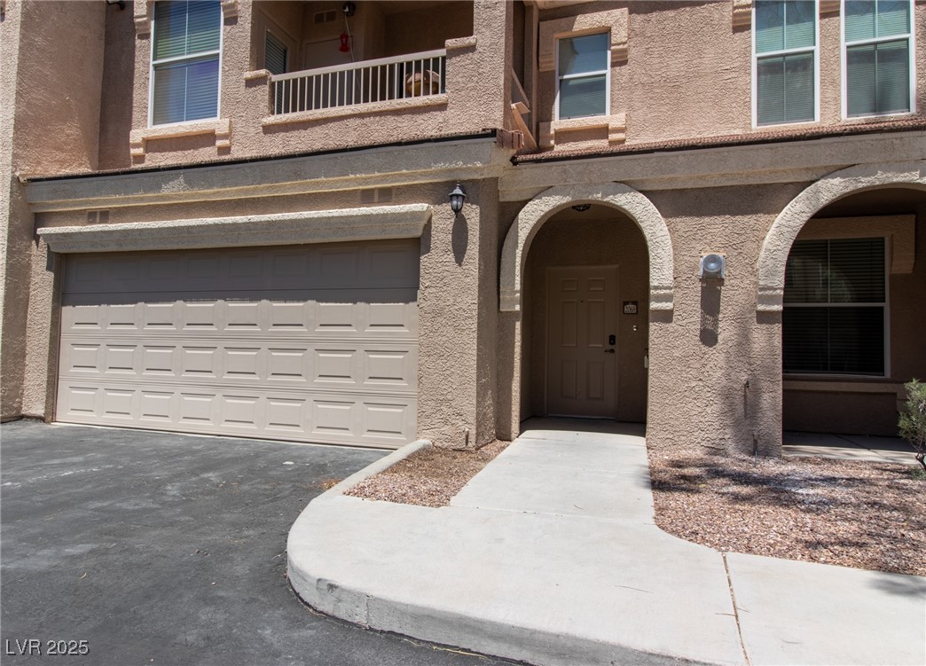 10550 West Alexander Road, Unit 2068 Las Vegas, NV 89129 - Photo 35 of 47 Doorway to property with driveway and stucco siding