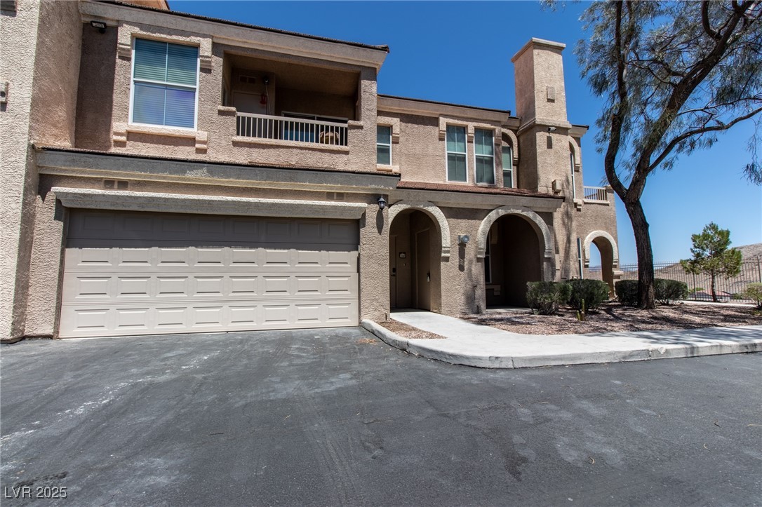 10550 West Alexander Road, Unit 2068 Las Vegas, NV 89129 - Photo 37 of 47 View of front of home featuring a balcony, driveway, stucco siding, and a garage