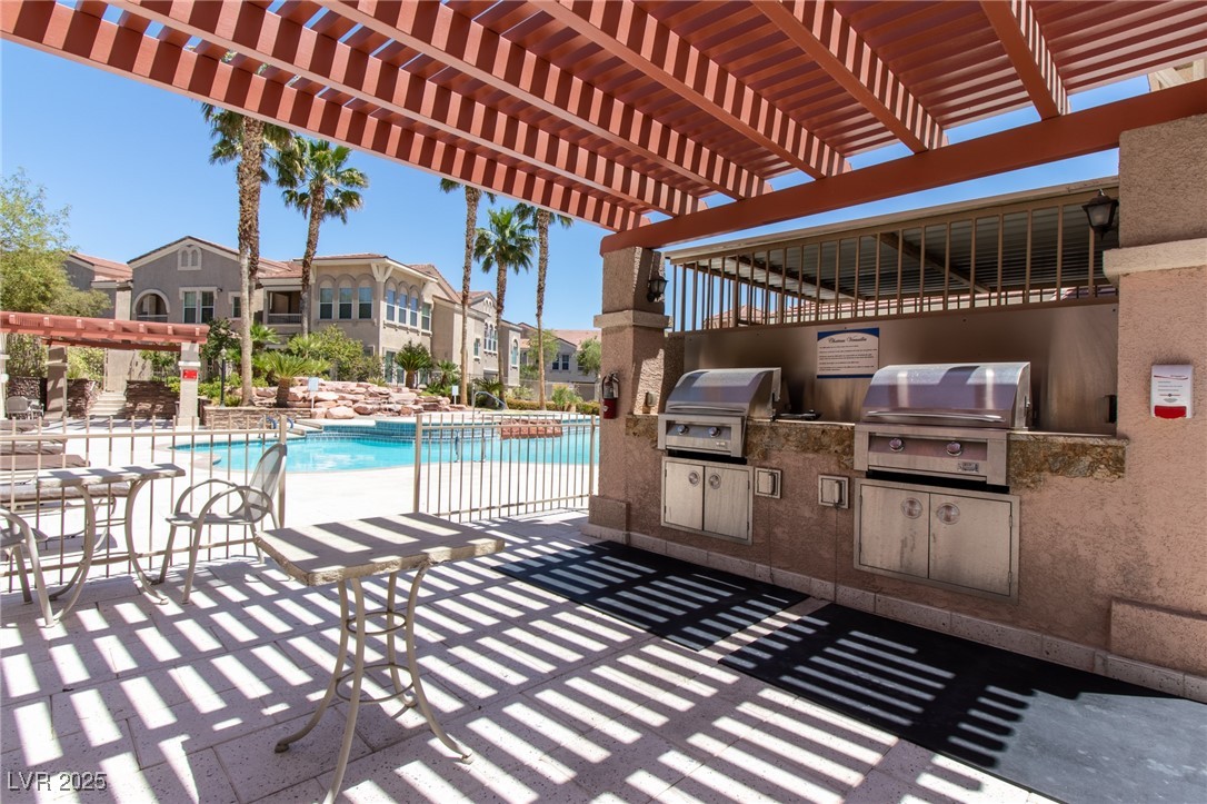 10550 West Alexander Road, Unit 2068 Las Vegas, NV 89129 - Photo 43 of 47 View of patio / terrace with a pergola, a community pool, and exterior kitchen