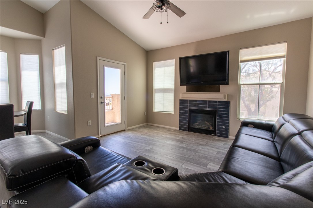 10550 West Alexander Road, Unit 2068 Las Vegas, NV 89129 - Photo 5 of 47 Living room with light wood-type flooring, lofted ceiling, plenty of natural light, and a tiled fireplace