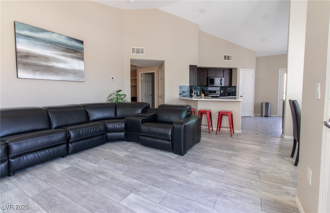 10550 West Alexander Road, Unit 2068 Las Vegas, NV 89129 - Photo 6 of 47 Living area with light wood-style floors and high vaulted ceiling