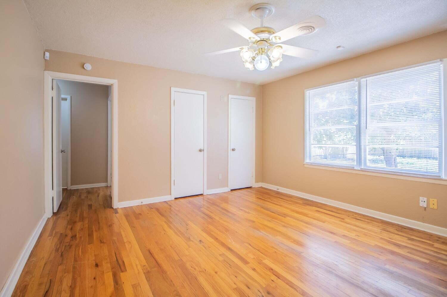 3813 35th Street Lubbock, TX 79413 - Photo 13 of 18 a view of an empty room with a window and wooden floor