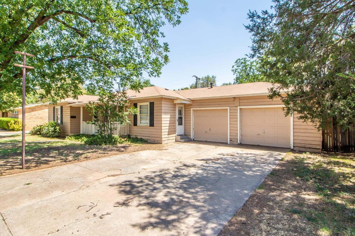 3813 35th Street Lubbock, TX 79413 - Photo 2 of 18 a front view of a house with a garden and trees